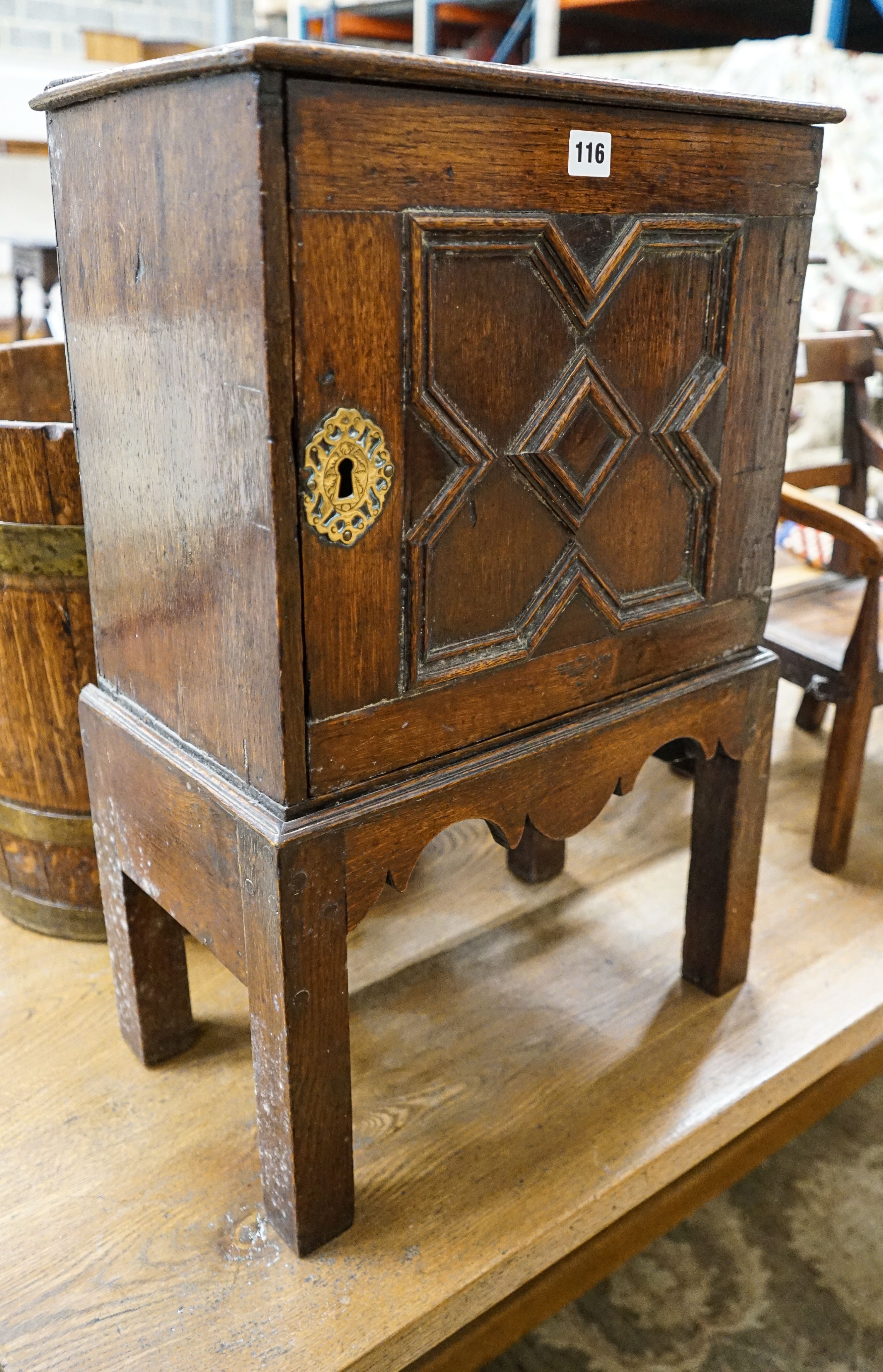 A late 17th century oak spice cupboard, with geometric panelled door enclosing five small drawers, on later stand, width 43cm, depth 27cm, height 67cm